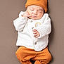 adorable, baby, barefeet, child, clothing, cozy, cute, expression, hat, headwear, indoor, infant, lying_down, newborn, orange_pants, peaceful, portrait, sleeping, soft_lighting, white_jacket