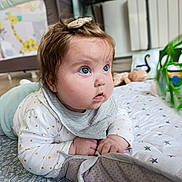 Lila participe au concours pour gagner de l'argent avec cette photo : baby, infant, child, blue_eyes, chubby_cheeks, hair_clip, bib, play_mat, plush_toy, playpen, giraffe_pattern, plant, blanket, crawling, indoor, portrait, close_up, star_pattern, clothing, curious_expression