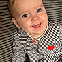 baby, child, smiling, face, striped_clothing, onesie, strawberry_patch, blue_eyes, happy, cute, portrait, infant, closeup, sitting, indoors, texture, background, small_child, person, joyful