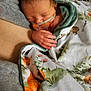 baby, blanket, close_up, cozy, cute, floral_blanket, fox_pattern, hospital_setting, medical_tube, nasal_cannula, newborn, pacifier, parent_arm, peaceful, portrait, skin_to_skin, sleeping_baby, soft_texture, swaddled, tiny_hand