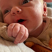 Thylio participe au concours pour gagner de l'argent avec cette photo : baby, blanket, child, closeup, clothing, cozy, cute, expression, eyes, face, hand, human, indoors, infant, newborn, portrait, resting, skin, soft, young