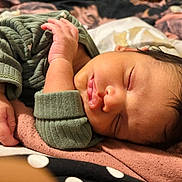Liam is registered to the contest to win money with this photo: infant, baby, newborn, sleeping, face, hand, blanket, bedding, onesie, closeup, portrait, cozy, soft_texture, eyelashes, hair, skin, indoor, peaceful, pudgy, resting