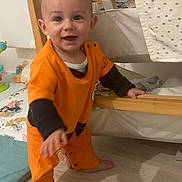 Saacha a rejoint le concours — aidez-le/la à gagner de superbes lots ! baby, barefoot, child, child_room, crawling, face, floor, furniture, happy, home, indoor, orange_clothing, person, playmat, smiling, toddler, toy, walking, wooden_crib, young_child