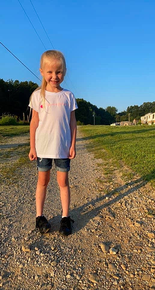 Anna is registered to the contest to win money with this photo: asphalt, ecoregion, grass, grassland, happy, horizon, joy, landscape, leisure, mammal, natural_environment, people_in_nature, person, plain, plant, shorts, sky, smile, sunlight, t_shirt