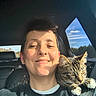 Beo is registered to the contest to win money with this photo: animal, blue_sky, car, casual, cat, clouds, daylight, happy, indoor, lip_piercing, person, pet, portrait, seat, seatbelt, shoulder, smile, sunlight, tabby_cat, window