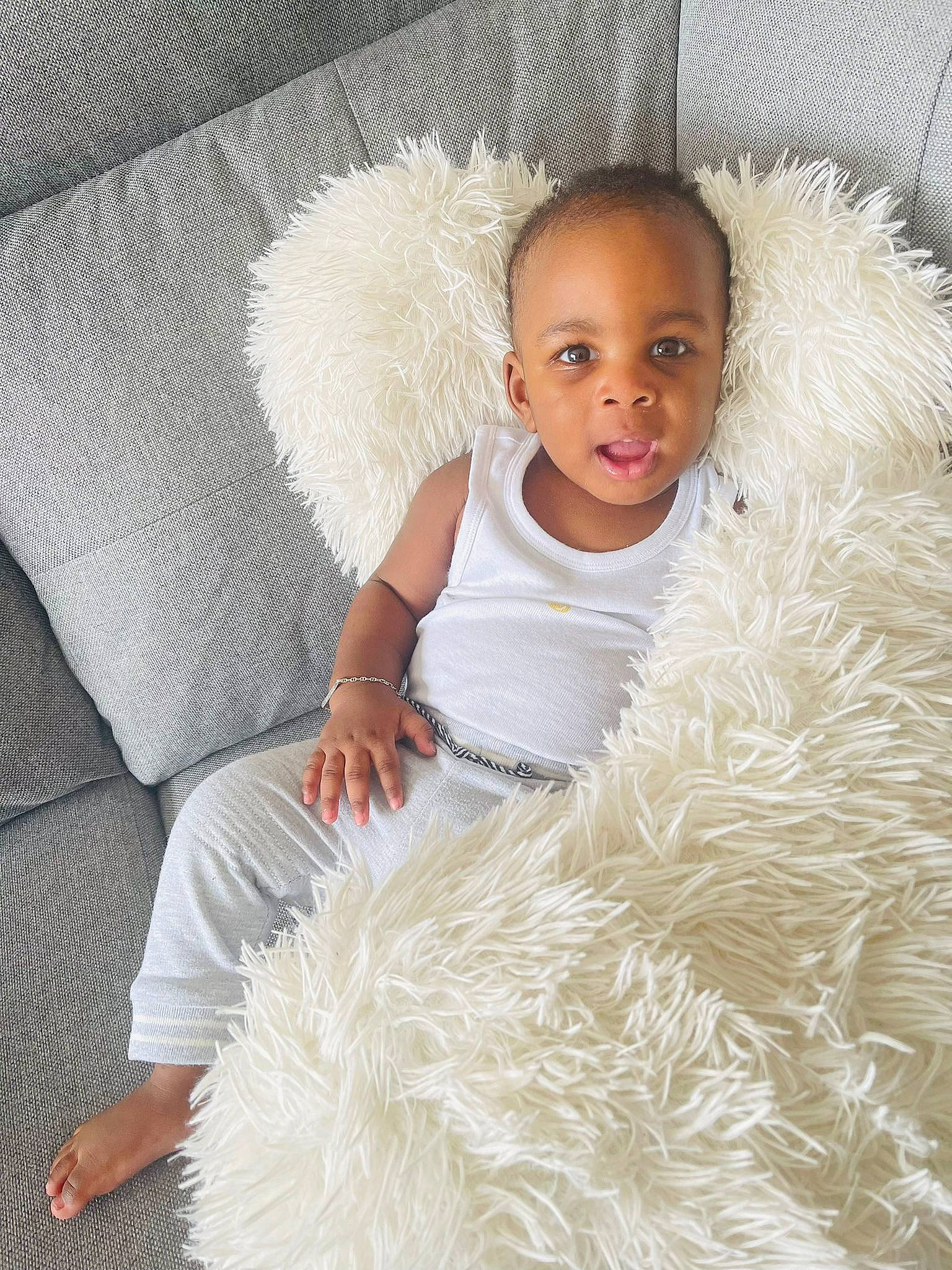 Lyann participe au concours pour gagner de l'argent avec cette photo : baby, baby_toddler_clothing, child, comfort, couch, electronic_device, face, fur, fur_clothing, hairstyle, happy, head, headgear, iris, linens, person, sitting, skin, textile, toddler