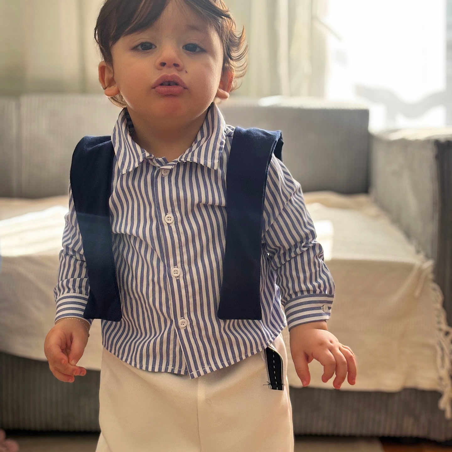Zayn Luqman a rejoint le concours — aidez-le/la à gagner de superbes lots ! toddler, child, indoor, striped_shirt, pants, suspenders, living_room, carpet, sofa, curtains, window, young_child, standing, portrait, person, cute, home, casual_clothing, floor, natural_light