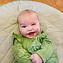 Adalynn is registered to the contest to win money with this photo: baby, child, smile, green_dress, infant, cute, happy, face, hands, lying_down, quilted_mat, soft_texture, indoors, portrait, young_child, toddler, clothing, baby_girl, joyful, expression