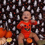 Carson is registered to the contest to win money with this photo: baby, child, pumpkin, halloween, orange_clothing, onesie, smile, happy, ghost_pattern, blanket, festive, seasonal, cute, sitting, sock, decoration, celebration, holiday, fun, portrait