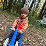 Marcelo joined the competition — help win amazing prizes! toddler, child, balance_bike, blue, beanie, hoodie, cars_movie, outdoor, forest, trees, leaves, autumn, path, dirt_path, casual_clothing, young_child, person, footwear, nature, play