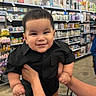 Emiliano joined the competition — help win amazing prizes! baby, child, infant, smiling, happy, portrait, black_outfit, short_hair, supermarket, grocery_store, shopping_cart, store_aisle, shelves, retail, indoors, shopping, adult_hands, standing, closeup, family