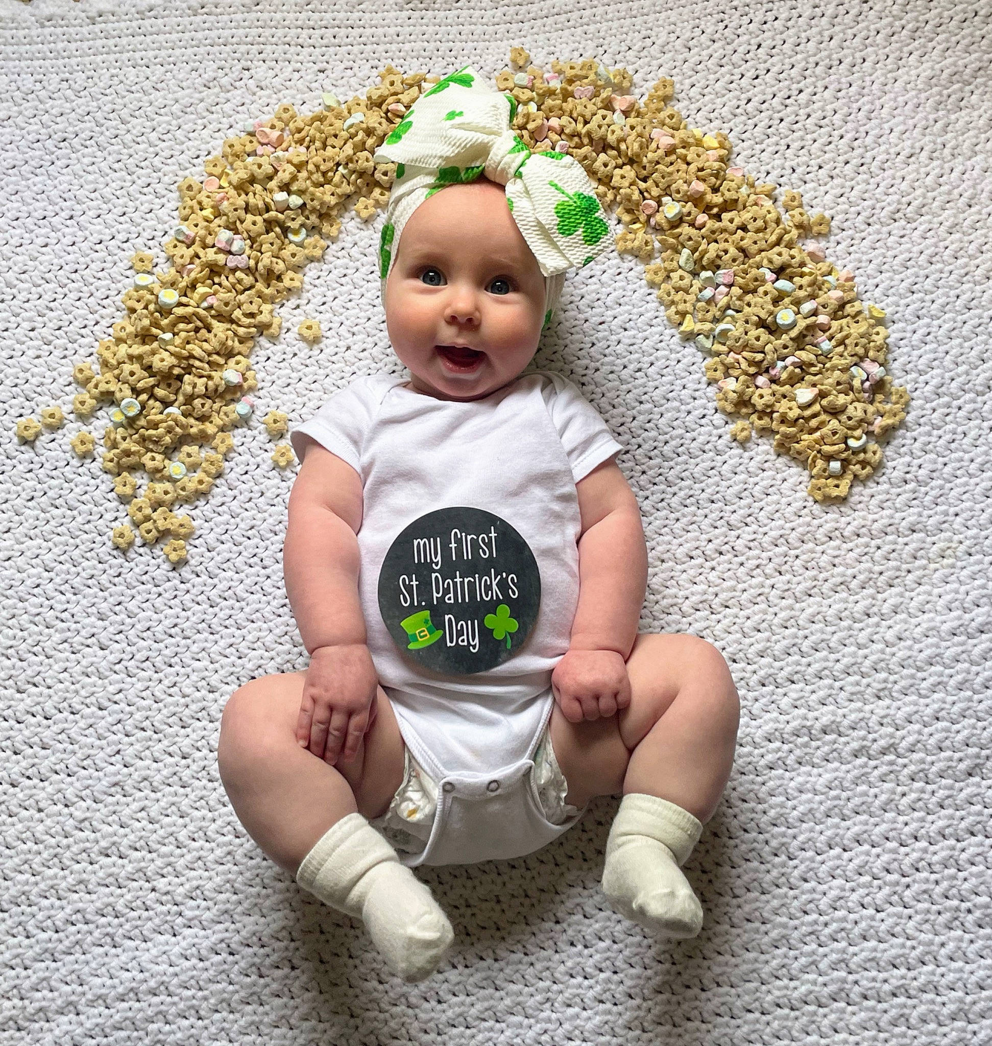 Maci is registered to the contest to win money with this photo: baby, baby_toddler_clothing, child, costume_hat, fashion_accessory, flooring, foot, fun, grass, happy, headwear, human_leg, jewellery, pattern, people_in_nature, person, sitting, sock, thigh, toddler