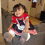Kehlani joined the competition — help win amazing prizes! toddler, child, smiling, boots, dress, red, black, white, couch, indoor, living_room, happy, girl, floor, hair_bow, portrait, cute, clothing, furniture, playful