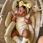 Alaia is registered to the contest to win money with this photo: baby, infant, child, smiling, portrait, indoor, baby_swing, bouncer, headband, bow, lemon_pattern, white_outfit, socks, plush_toy, dolphin, toy, cozy, seated, happy, home