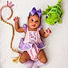 Alaia joined the competition — help win amazing prizes! baby, infant, child, portrait, lying_down, costume, princess, purple_bow, pink_dress, socks, plush_toy, dragon, crown, braided_hair, white_blanket, indoor, top_down, adorable, playful, photography