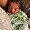 Nyaire is registered to the contest to win money with this photo: baby, newborn, infant, sleeping, smiling, blanket, dinosaur_pattern, clothing, closeup, face, person, couch, leather, comfort, warmth, cozy, rest, portrait, child, toddler