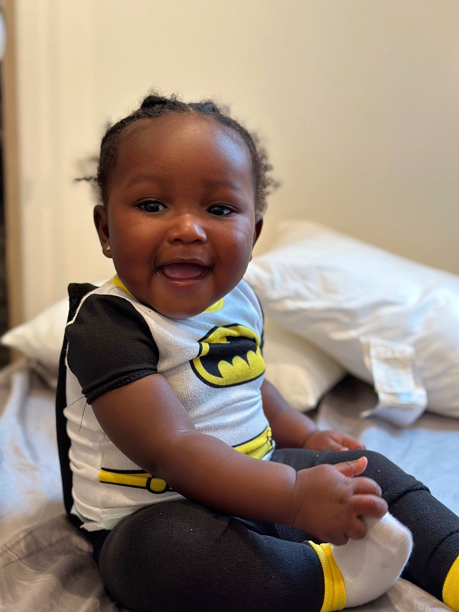 Dakari is registered to the contest to win money with this photo: arm, baby, baby_toddler_clothing, cheek, child, comfort, elbow, eye, flash_photography, flooring, fun, hand, happy, person, room, sitting, skin, sleeve, smile, t_shirt