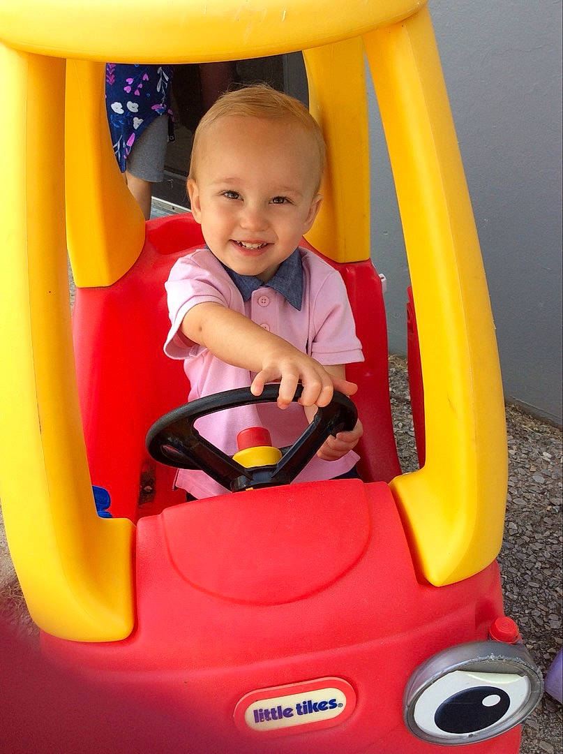 Liam is registered to the contest to win money with this photo: automotive_design, automotive_exterior, baby, baby_toddler_clothing, bumper, child, fender, fun, happy, joy, leisure, motor_vehicle, person, play, playground, product, riding_toy, smile, snapshot, tire