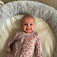 Alaina joined the competition — help win amazing prizes! baby, infant, smile, onesie, floral_pattern, cushion, plush, soft_texture, face, lying_down, comfortable, cozy, happy, indoor, child, cute, patterned_clothing, head, small_hands, carpet