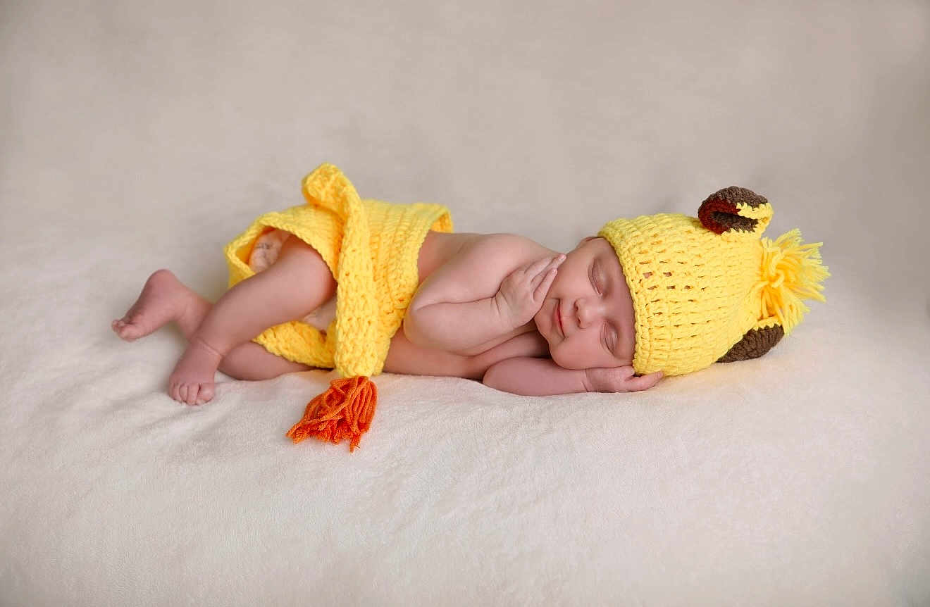 Alaina is registered to the contest to win money with this photo: baby, newborn, sleeping, knitted_hat, yellow_clothing, blanket, soft_texture, peaceful, infant, child, resting, cute, portrait, indoors, warm_colors, cozy, adorable, hand, face, skin