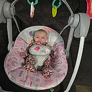 Lilah joined the competition — help win amazing prizes! baby, infant, swing, baby_swing, indoor, couch, carpet, toy, hanging_toy, pink, pattern, clothing, smile, face, child, seat, fabric, person, cute, playful