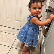 Delilah joined the competition — help win amazing prizes! toddler, child, blue_dress, barefoot, bathroom, cabinet, curious, smile, face, person, floor, tile, door, rug, earrings, hairclip, standing, indoor, young_child, cabinet_handle