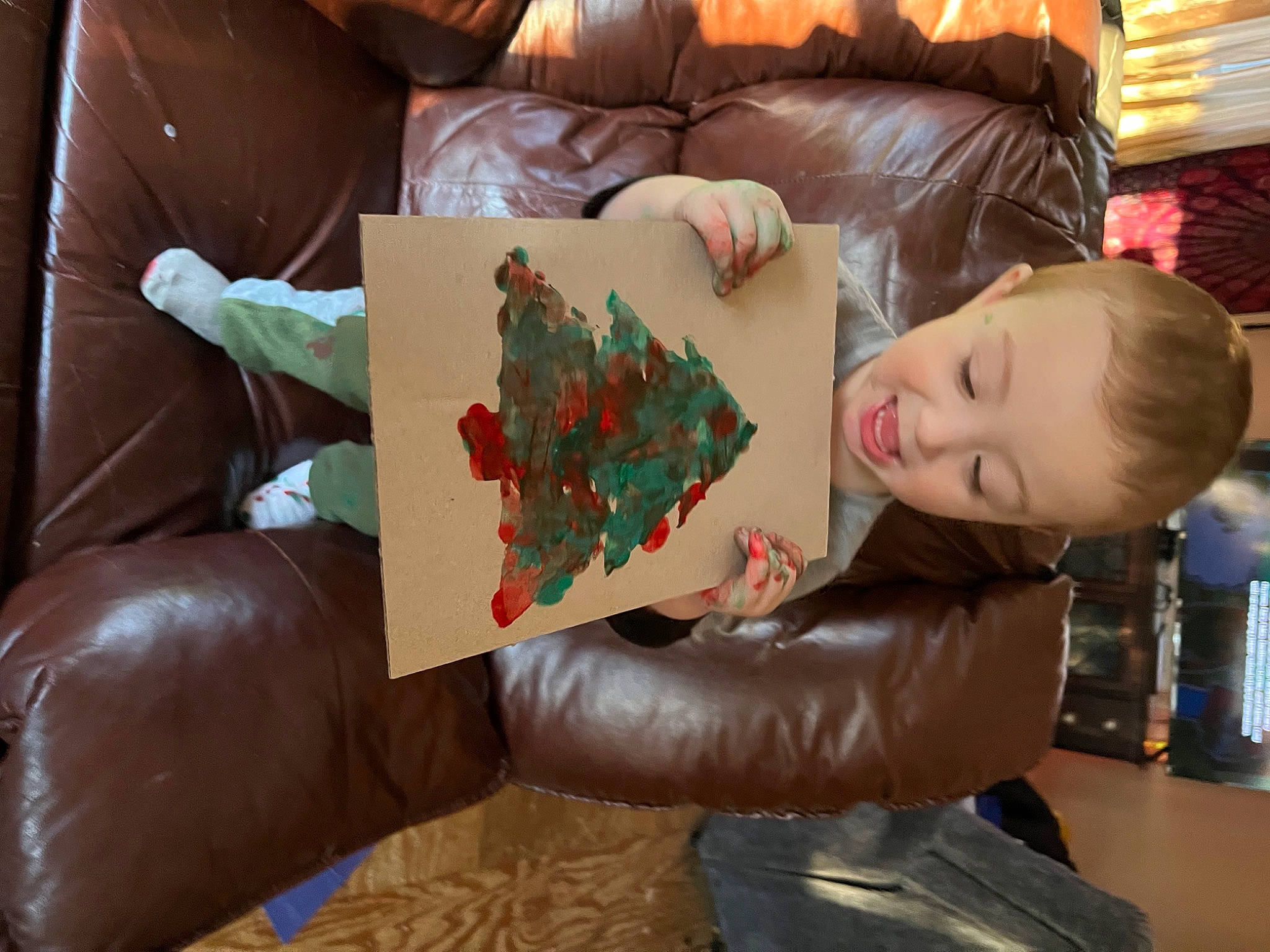 Frankie is registered to the contest to win money with this photo: art, artist, carmine, child, comfort, couch, finger, flooring, fun, house, leisure, living_room, person, pillow, play, room, sitting, textile, toddler, tree