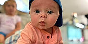 Easton is registered to the contest to win money with this photo: baby, child, blue_cap, curious, face, indoor, infant, person, portrait, tummy, young_child, clothing, short_sleeve, cute, wide_eyes, focus, background_blur, skin, hands, expression