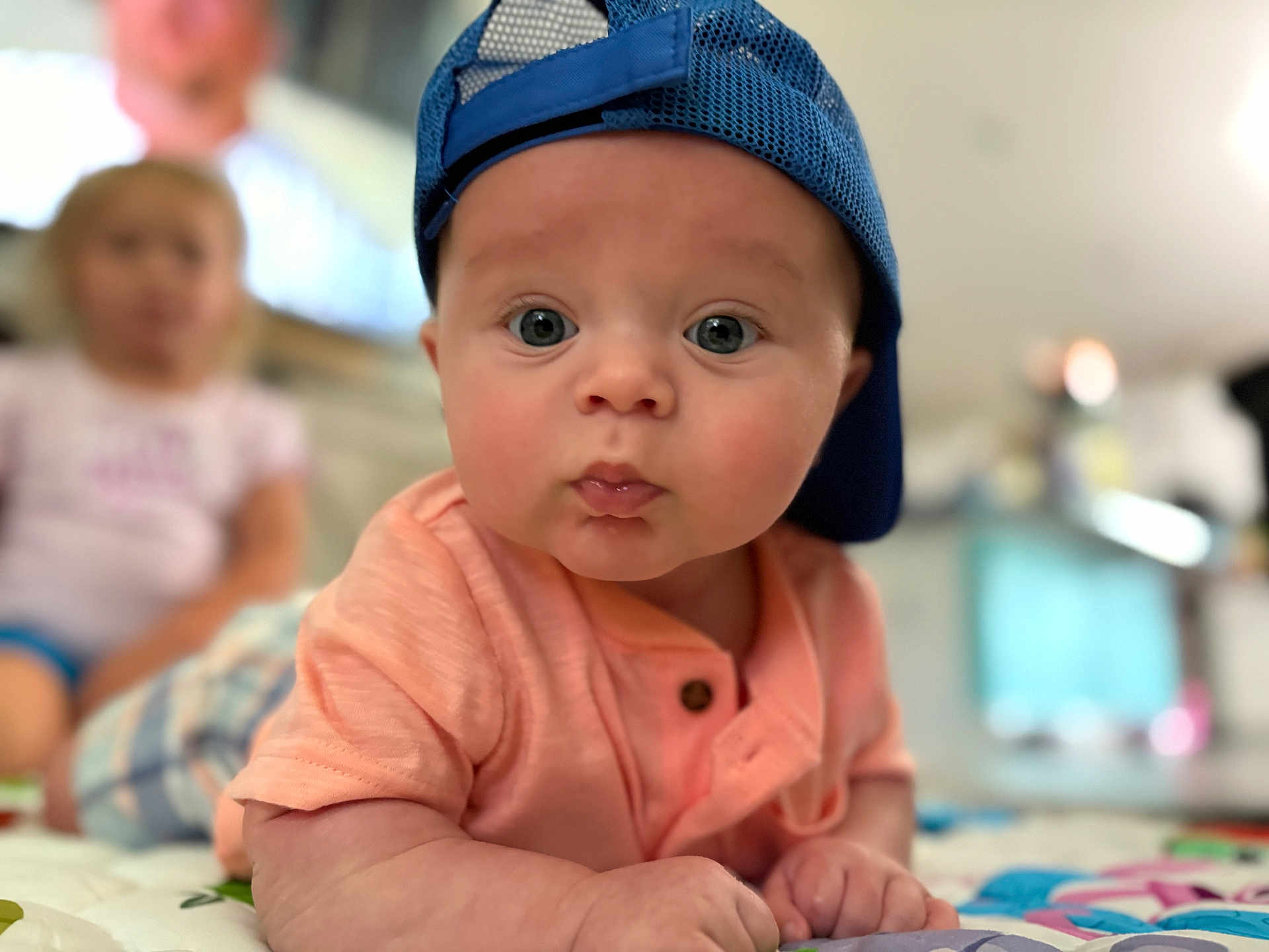 Easton is registered to the contest to win money with this photo: baby, child, blue_cap, curious, face, indoor, infant, person, portrait, tummy, young_child, clothing, short_sleeve, cute, wide_eyes, focus, background_blur, skin, hands, expression