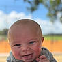 Easton is registered to the contest to win money with this photo: baby, smiling, face, hand, skin, outdoor, blue_blanket, happy, infant, cute, portrait, head, expression, child, person, daylight, nature, soft_texture, closeup, blurry_background