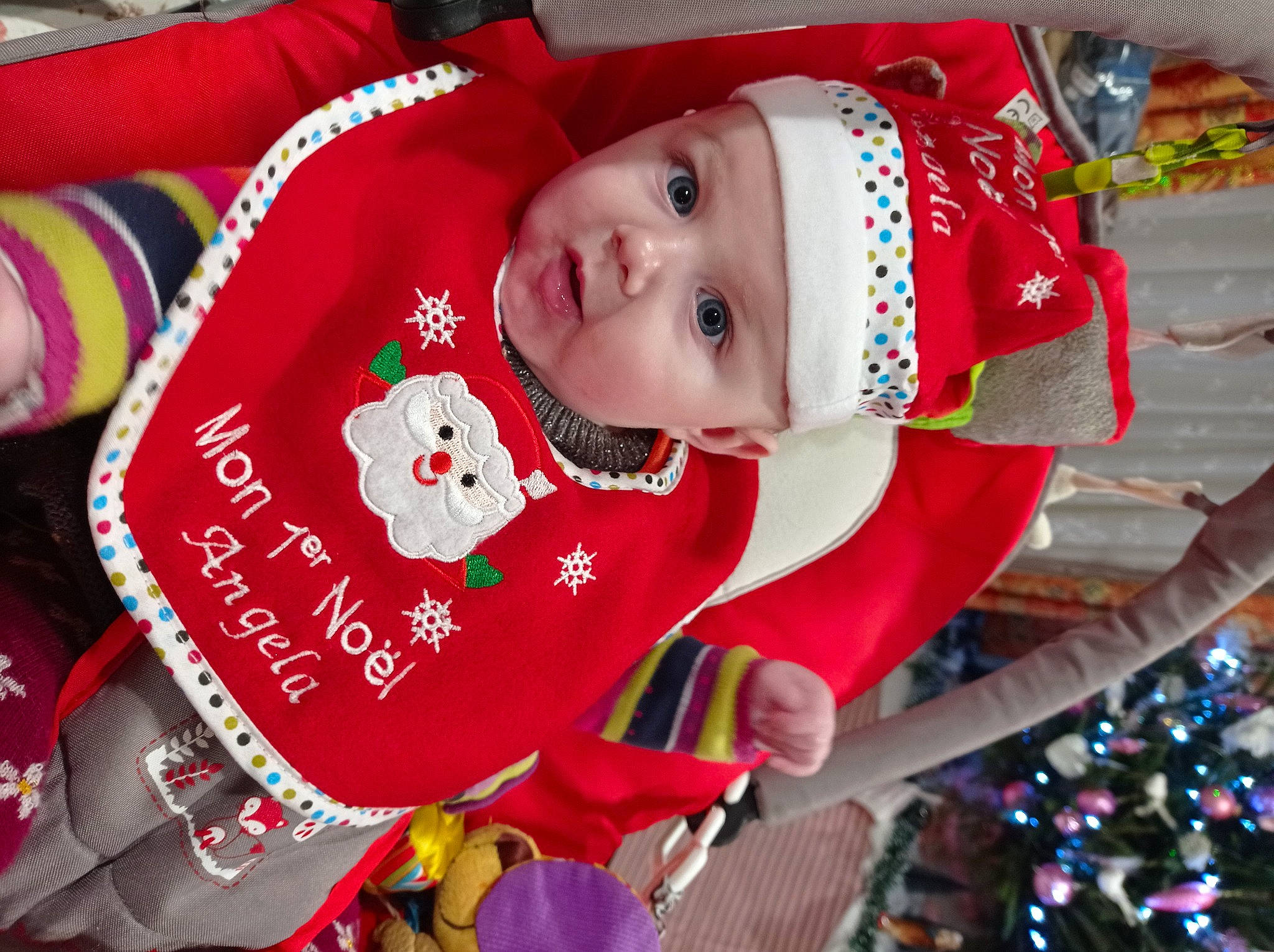 Angela a rejoint le concours — aidez-le/la à gagner de superbes lots ! baby, baby_toddler_clothing, carmine, child, christmas, christmas_decoration, christmas_eve, christmas_ornament, christmas_tree, event, fictional_character, fun, happy, headwear, holiday, ornament, person, red, sleeve, toddler