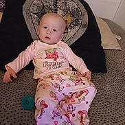 Nova is registered to the contest to win money with this photo: baby, child, pajamas, french_fries, donut, hot_dog, pacifier, couch, pillow, textile, pattern, clothing, indoor, person, foot, head, face, seated, soft_furnishing, relaxed