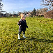 Alfie joined the competition — help win amazing prizes! boots, child, clothing, daytime, field, grass, happy, jacket, leaf, nature, outdoor, park, person, playground, sky, smile, sunlight, toddler, tree, young_child