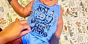 Korbin is registered to the contest to win money with this photo: baby, blanket, blue_outfit, child, cute, expression, feet, hand, happy, head, indoors, infant, legs, lying_down, mittens, patterned, person, playful, skin, smiling