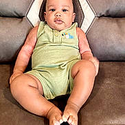 Korbin joined the competition — help win amazing prizes! baby, child, infant, couch, leather, green_onesie, toucan_embroidery, feet, hands, face, eyes, ears, sitting, indoor, furniture, cute, plump, relaxed, portrait, young