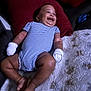 baby, infant, smile, striped_onesie, mittens, blanket, pillow, happy, lying_down, indoor, child, cute, skin, foot, hand, cozy, comfort, cheerful, portrait, relaxed