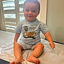 Emmett is registered to the contest to win money with this photo: baby, child, smile, sitting, indoor, shirt, shorts, duck, window, blinds, medical_table, feet, legs, arm, face, happy, cute, young_child, clothing, person