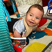 Vittorio is registered to the contest to win money with this photo: baby, smiling, play_mat, toy, mirror, indoor, child, colorful, happy, infant, clothing, face, cute, toddler, patterned, fabric, room, soft_toys, lying_down, curious