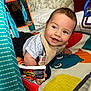 baby, smiling, play_mat, toy, mirror, indoor, child, colorful, happy, infant, clothing, face, cute, toddler, patterned, fabric, room, soft_toys, lying_down, curious