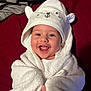 baby, smiling, towel, hood, cute, child, happy, face, wrapped, cozy, white, blanket, red_background, infant, portrait, soft, cute_clothing, lying_down, expression, warm